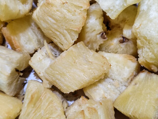 Fried cassava, golden yellow in color and crispy texture can be seen filling the entire frame,...