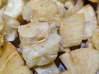 Fried cassava, golden yellow in color and crispy texture can be seen filling the entire frame,...