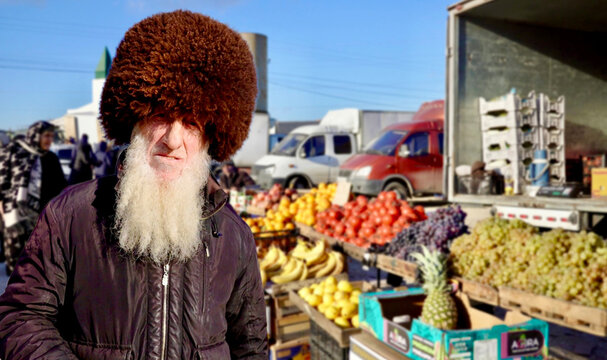 Caucasian man in a papakha stands at the market