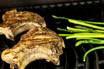 Cooking steak on a gas grill with vegetables.