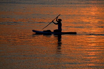 silhouette of a person kayaking at sunset