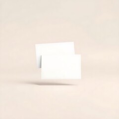 Two clean white business cards float elegantly against a gentle beige backdrop for modern corporate branding.