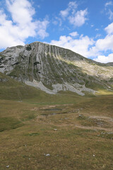 Landscape of mountains and lake at the foot of the mountain. Montenegro, Durmitor National Park against the background of the sky with clouds. View of Berg Prutas Mountain.