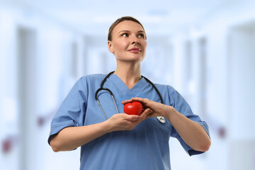 Nurse is proudly displaying a heart symbol in the hospital