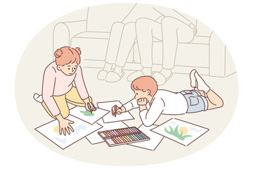 Little boy and girl painting together sitting on floor doing art spending time with family