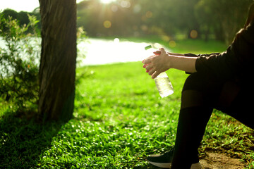 Thirsty girl drinking water Hot day Young woman Jogging Playing sports and living a healthy life...