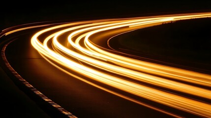 Light trails of cars on a highway curve at night