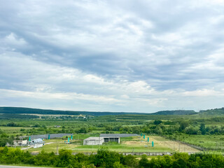 Expansive rural landscape with cloudy sky and lush greenery.