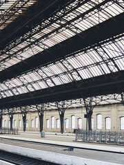 Empty train station platform under an industrial roof.