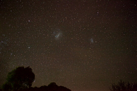 Night sky with stars and the large and small magellanic cloud galaxies