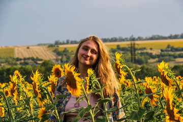 blonde woman in field of yellow sunflowers, portrait, looking into lens, smiling, teenager, bright...