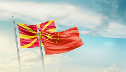 North Macedonia and China flags waving in beautiful sky. Two country flag for agreement or deal....