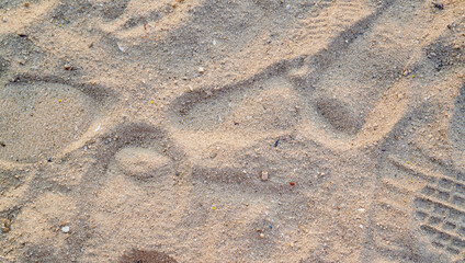 Full-frame image of sandy beach with a visitor's footprints in the centre of the frame
