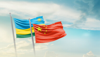 Rwanda and China flags waving in beautiful sky. Two country flag for agreement or deal. Rwanda...