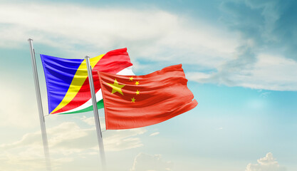 Seychelles and China flags waving in beautiful sky. Two country flag for agreement or deal....