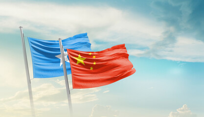 Somalia and China flags waving in beautiful sky. Two country flag for agreement or deal. Somalia...