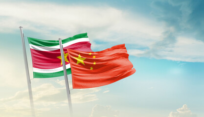 Suriname and China flags waving in beautiful sky. Two country flag for agreement or deal. Suriname...