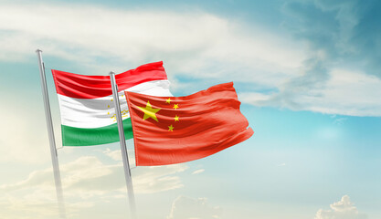 Tajikistan and China flags waving in beautiful sky. Two country flag for agreement or deal....