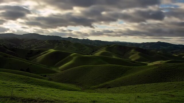 Stunning rolling green hills landscape with dramatic cloudscape at Teletubbies hills Nusa Penida