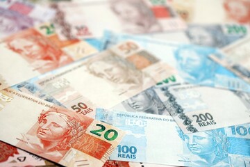 Brazilian reais banknotes. The current Brazil real money bills lies on table in big amount