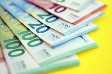 Big amount of european euro currency money notes on yellow color table close up