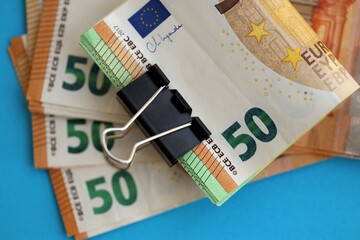 Big amount of european euro currency money notes on blue color table close up
