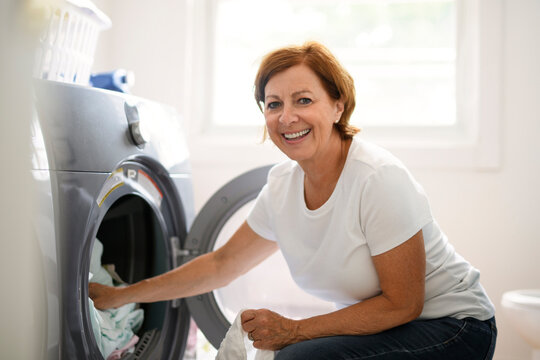 senior Woman Doing Laundry near a Washing Machine