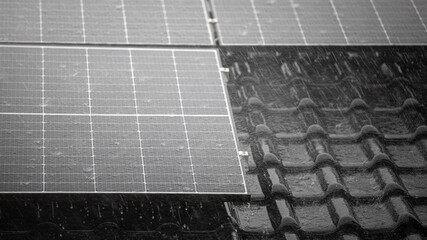 Corner of solar panels on roof with heavy rain splashes 
