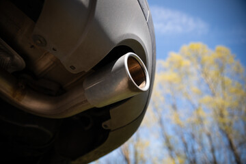 Used car exhaust pipe with visible wear and blurred background
