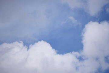 Obraz premium Bright blue sky with soft white clouds scattered across a clear day, evoking a sense of peace and natural freshness