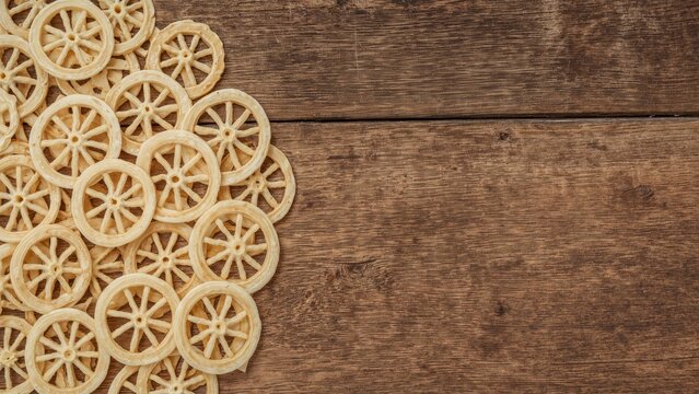 Wagon wheel pasta dried and arranged on wooden surface