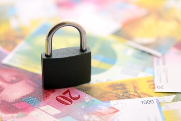 Swiss franc banknotes and padlock. The current francs money bills with lock lies in big amount