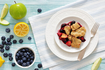 apple blueberry strawberry crumble on white plate