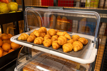 Freshly baked croissants displayed on tray in buffet restaurant