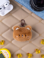 Close-up of a plush  keychain for a bag featuring a funny brown bear.