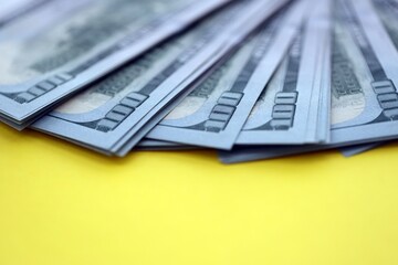 Big amount of United States hundred dollar bills on yellow background