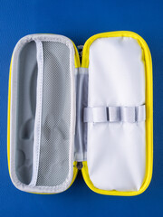 Close-up of a gray school pencil case in a hard format on a blue background