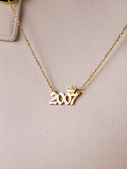 Close-up of a metallic gold pendant in the shape of 