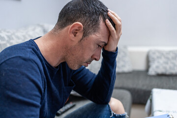 Depressed man suffering from anxiety and stress at home