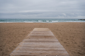 Beach boardwalk with waves and wet sand