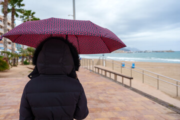 Woman walking with umbrella on boardwalk