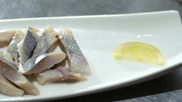 herring with onions Fish rolls with sour herring on green plate