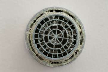 Calcified perlator (aerator) as seen directly from below. Wear and tear, and chunks of chalk can be...