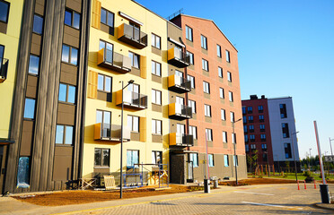New residential building after construction. New residential complex, condo block. Multi-colored facade of residential building. Completed construction of house. Multicolored Facade of condominium.
