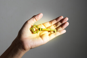 Bright light of golden color key in woman hand.