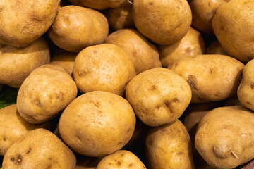 Many fresh potatoes as background, top view. Sell on supermarket.