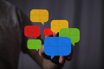 Colorful puzzle pieces forming speech bubbles illustrate teamwork, communication, and...