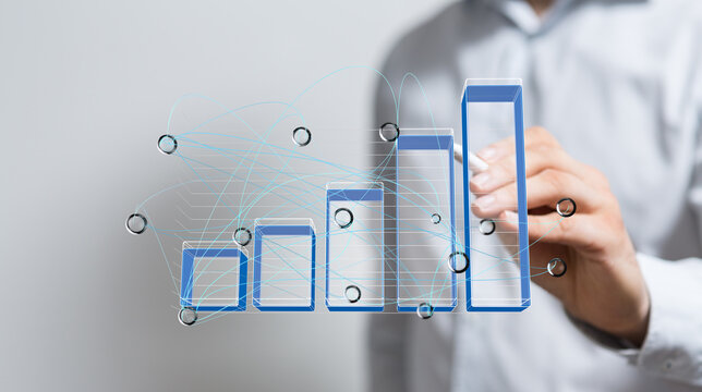 Stock photo of a businessman analyzing a growing bar chart, depicting data growth and business success.