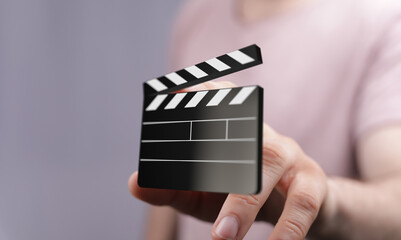 Person holds a virtual movie clapperboard.  Filmmaking, video production, media concept.