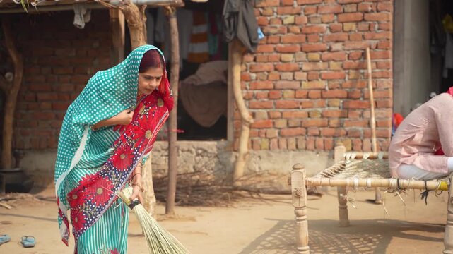 Indian rural woman cleaning with broom